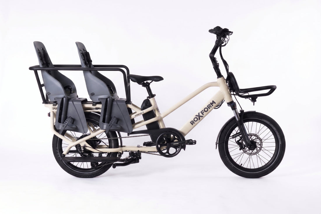 A Roxform longtail cargo e-bike fitted with two Urban Iki child seats and the Family Pack caboose, set up for carrying children